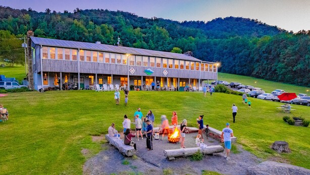 A lodge with a large dining area and a fire pit in the foreground. - Graves Mountain Farm & Lodges (Syria)