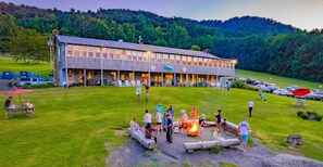 A lodge with a large dining area and a fire pit in the foreground. - Graves Mountain Farm & Lodges (Syria)