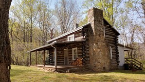 A rustic log cabin with a porch, surrounded by trees. - Graves Mountain Farm & Lodges (Syria)