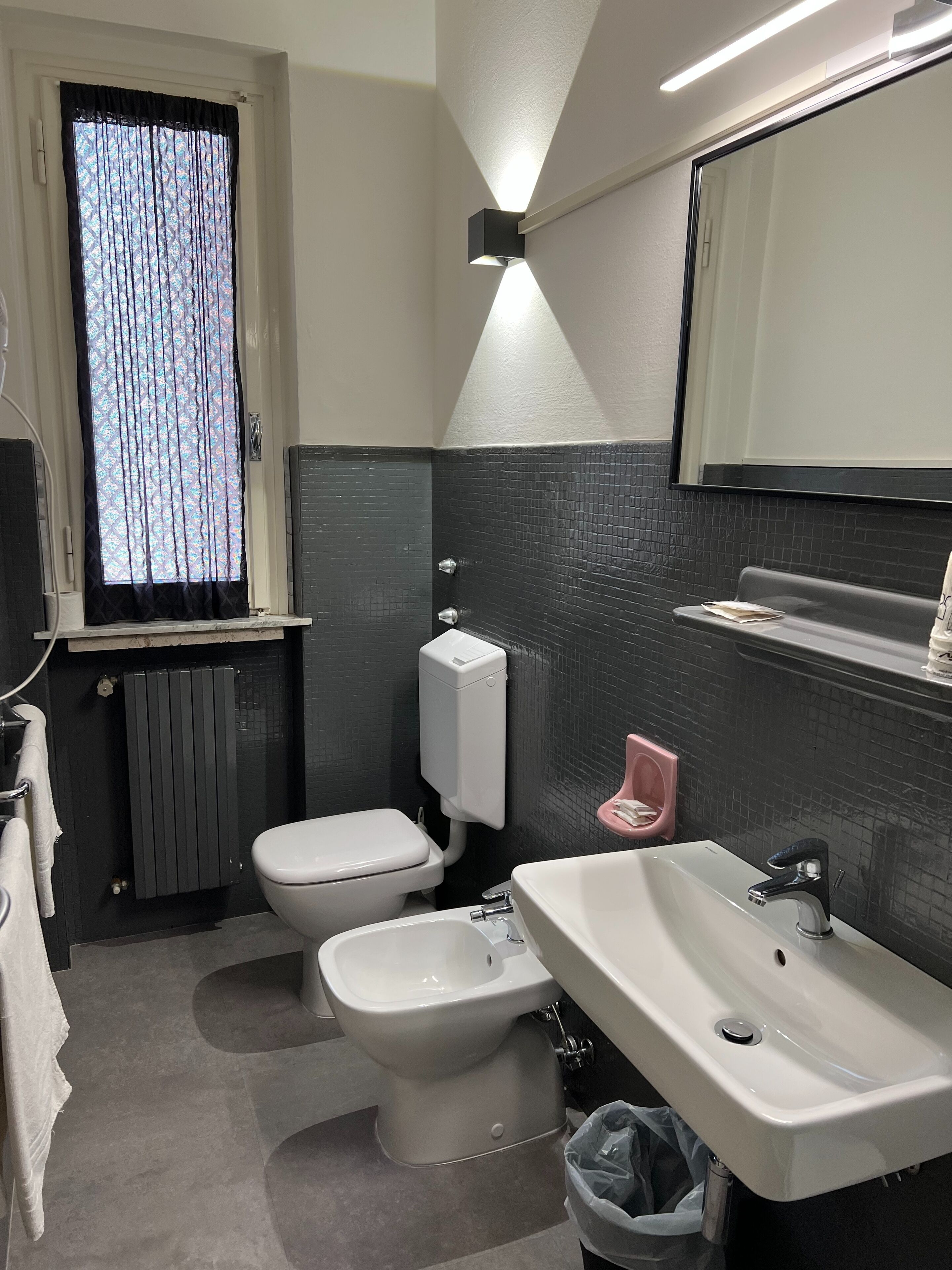 A modern bathroom with a toilet, bidet, and sink.