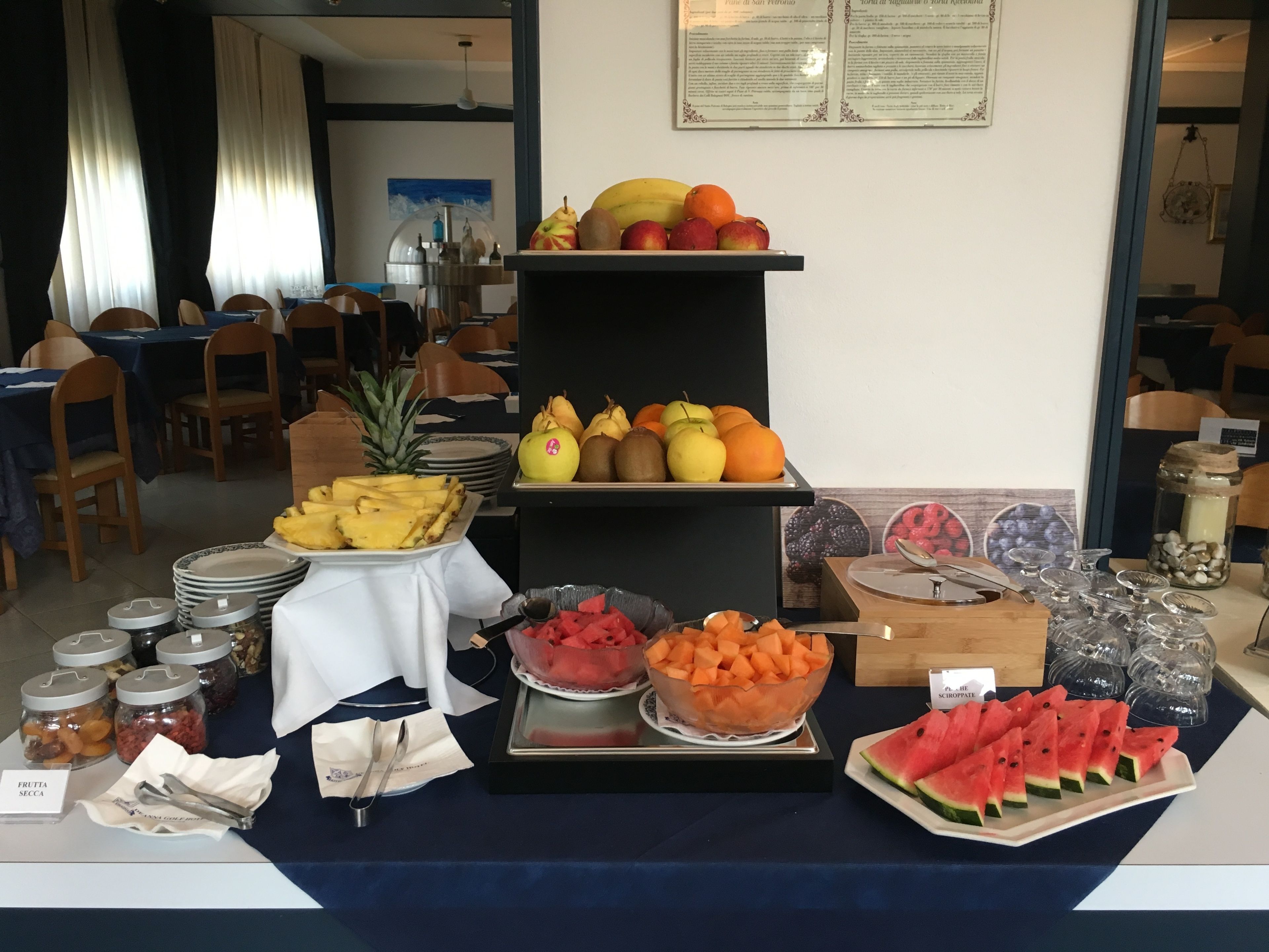 Un buffet proposant une variété de fruits et une sélection de pots, qui contiennent probablement des condiments ou des confitures.