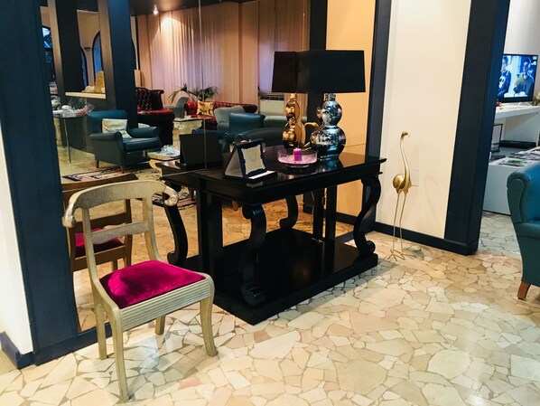Un salón con diseño moderno, que presenta una combinación de mobiliario, incluyendo un sofá, sillones y una mesa de centro.