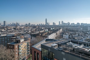 A high-rise building with multiple floors, large windows, and a rooftop terrace.