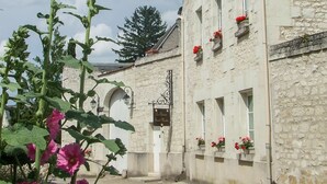 Un edificio de piedra con varias ventanas, algunas con macetas de flores.