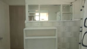 A bathroom with white tiled walls, a white sink, and a mirror above the sink. - 440 Cachagua (Zapallar)