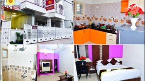 Ein Hotel mit Rezeption, einem Badezimmer mit Dusche, einer Küche mit orangenen Schränken und einem Schlafzimmer mit Bett und Nachttisch.