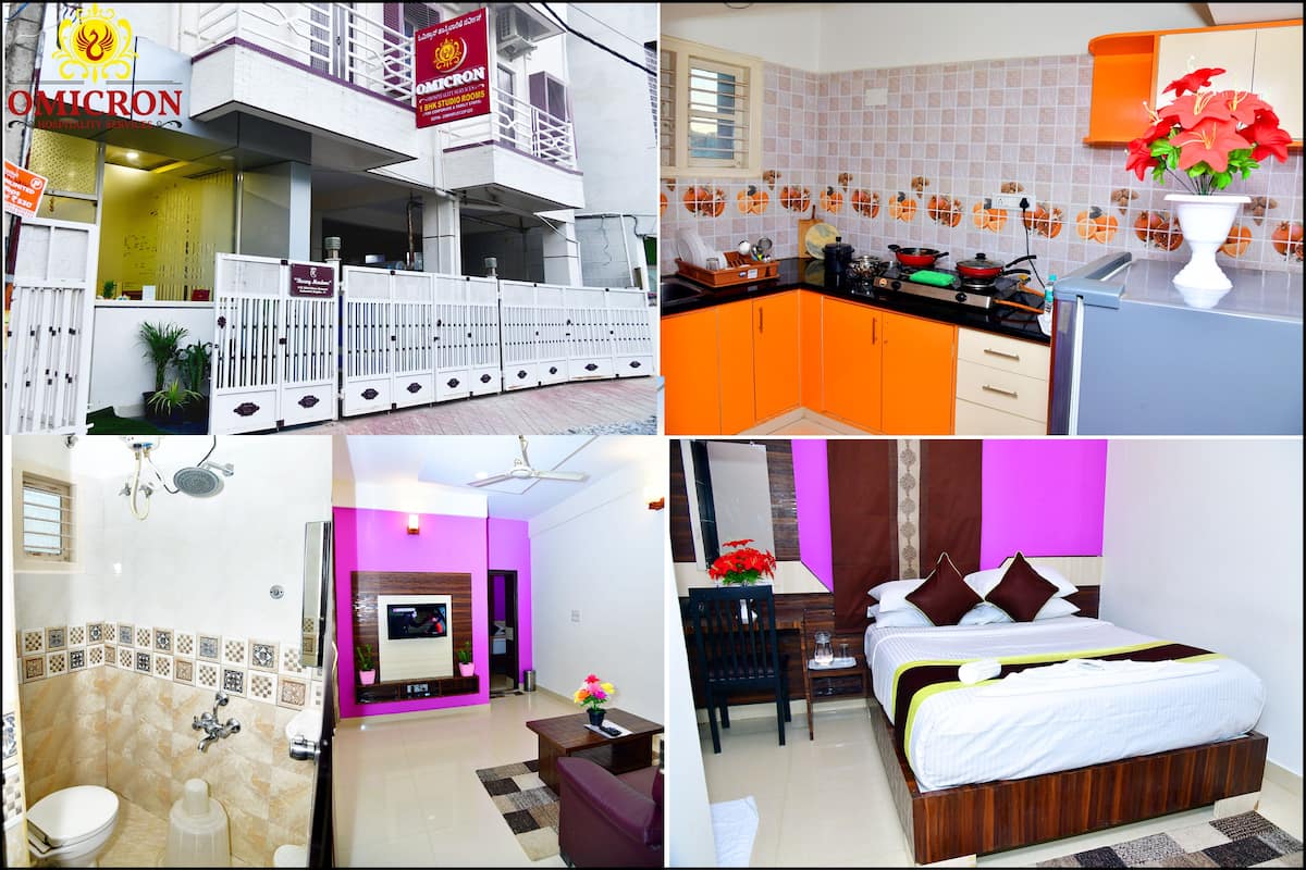 A hotel with a reception area, a bathroom with a shower, a kitchen with orange cabinets, and a bedroom with a bed and a nightstand.