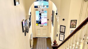 A carpeted staircase with a handrail, leading to a door with a sign above it. - The Hedley Townhouse (Bournemouth)