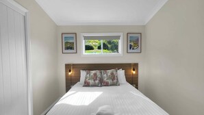 A bedroom with a bed, a window, and two framed pictures on the wall. - Villa 6 @ Bimbadeen Estate - Spa studio for 2 - Amazing views at every turn (Mount View)