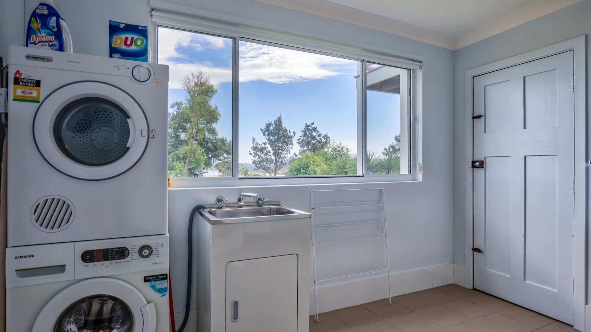 A laundry room with a washing machine, dryer, and a sink.