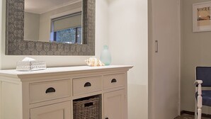 A bathroom vanity with a mirror, a tissue box, a seashell, and a decorative vase. - ROANJOKA - DROMANA.... (Dromana)