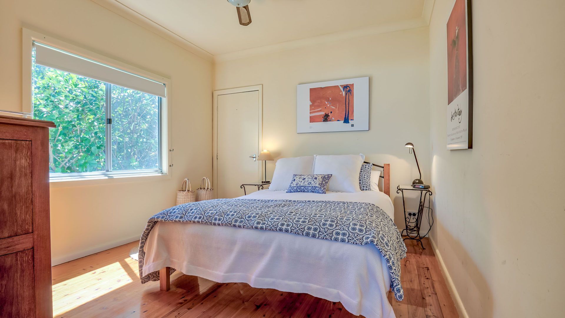 Una camera da letto con un letto, lampade sui comodini, una finestra e una porta.