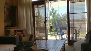 Una habitación acogedora con una mesa de madera, un sofá y un ventanal con vistas al exterior.