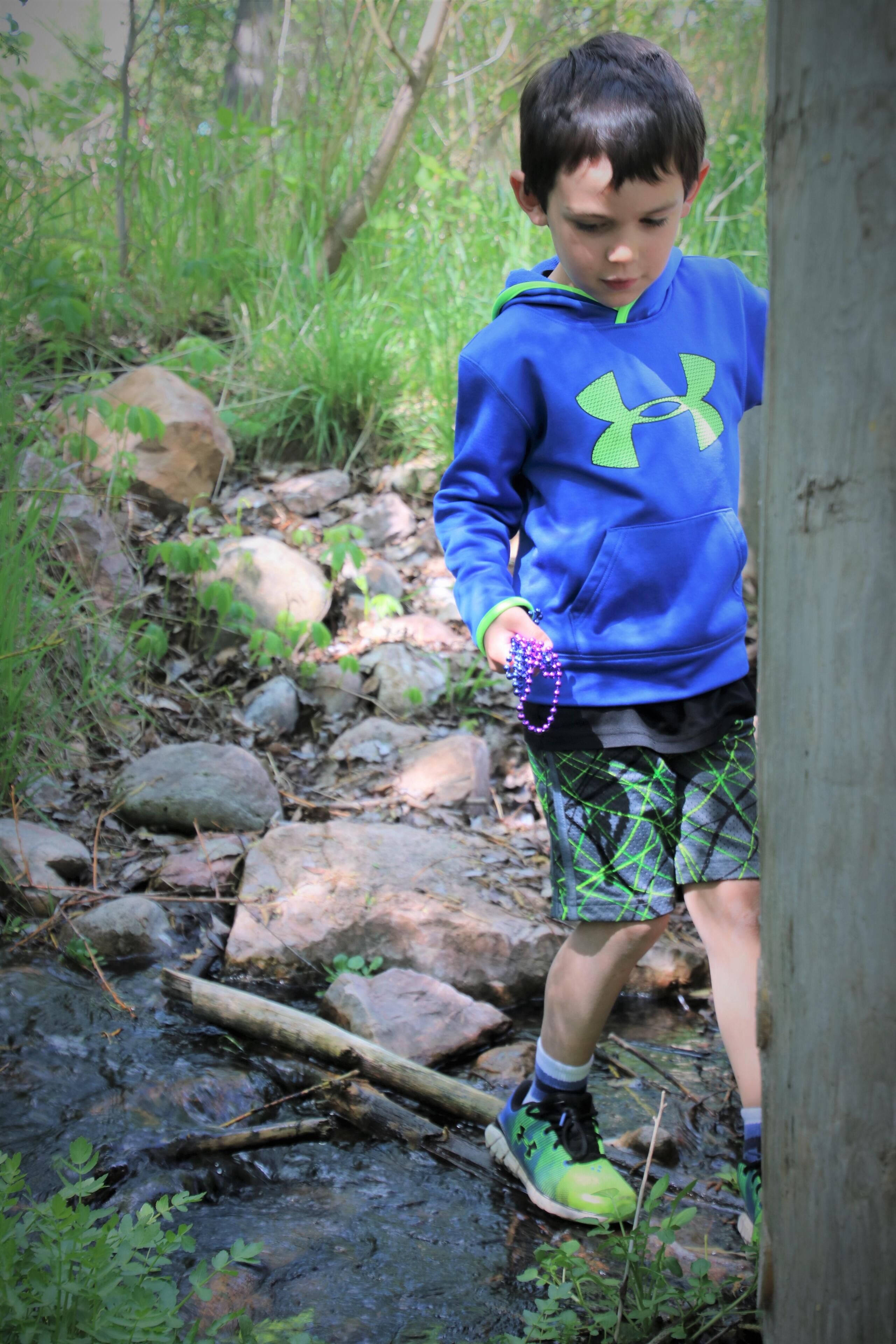A person standing on a rocky path in a natural setting.