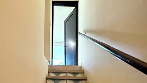 Uma escadaria com um padrão geométrico nos degraus e corrimão à direita.