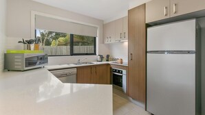 A modern kitchen with a built-in oven, microwave, and refrigerator.