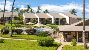 Ein Resort mit mehreren Bungalows, einem Swimmingpool und Palmen.