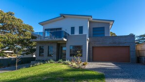 A modern two-story house with a garage, a balcony, and a well-maintained lawn. - Coastline, Boat Harbour - Gerringong (Gerringong)