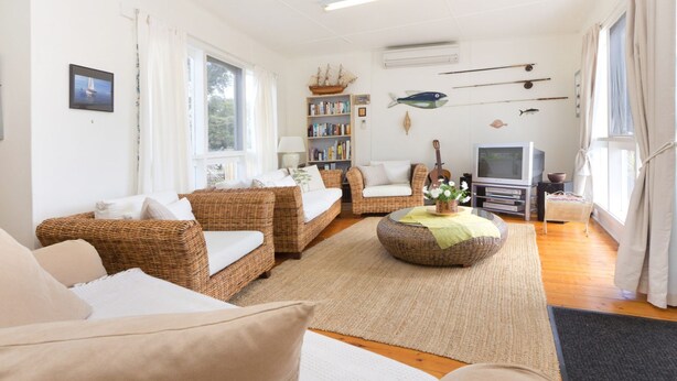A cozy living room with wicker furniture, a bookshelf, a television, and nautical decorations. - HOME SWEET HOME - MOUNT MARTHA (Mount Martha)