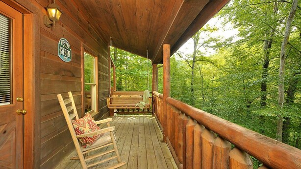 Eine Holzhütte mit Veranda, Schaukelstühlen und einem Schild, auf dem 'Vermont Cabin' steht.