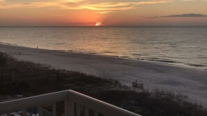 A beach with a sunset, a wooden fence, and a staircase leading down to the beach. - 🏖Beachfront Retreat on Perdido Key. Two Pools, Hot Tub, and Gym🏖 (Perdido Key)