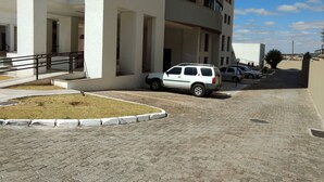 Un edificio a più piani con un'area di parcheggio.