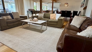 A living room with a brown leather sofa, a grey sofa, and a white coffee table.