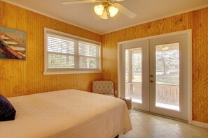 A bedroom with a bed, a ceiling fan, a window with blinds, and a door leading outside. - Waterfront Foley Area Home - 15 Mi to Gulf! (Elberta)
