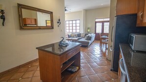 Een ruime woonkamer met keuken, een grote spiegel en een eethoek.
