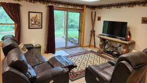 Ein Wohnzimmer mit Ledersofa, Fernseher und Kamin.