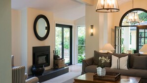 Un salon avec une cheminée, un canapé, une table basse et un grand miroir.