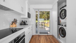 A compact kitchen with a microwave, kettle, and knife block. - Sunset on Headland, Gerroa (Gerroa)