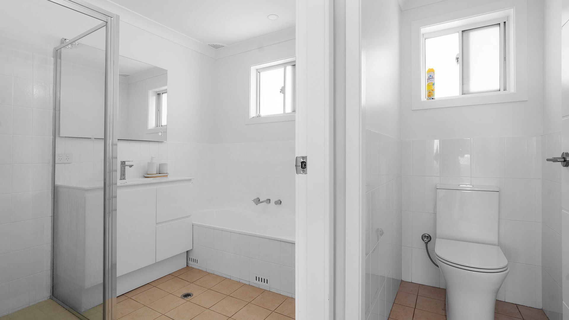 A bathroom with a toilet, a shower, and a sink.