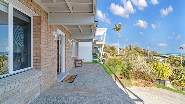 A modern house with a covered porch, a bench, and a view of the ocean. - Sunset on Headland, Gerroa (Gerroa)