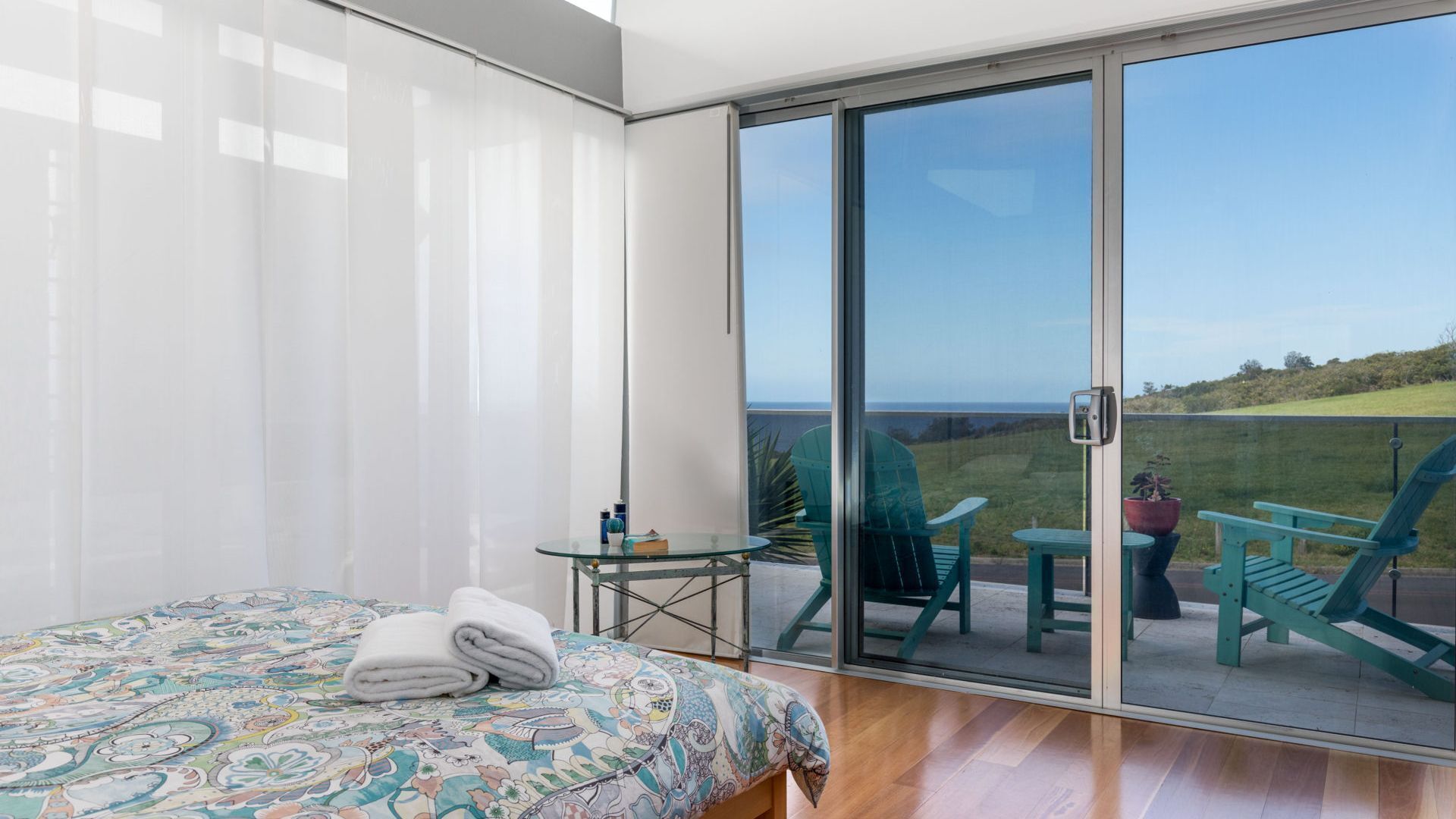 A balcony with a bed, a small table, and two chairs.