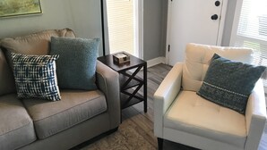 A living room with a grey sofa, a white armchair, and a small wooden table. - Capital City Condo #1 close to Interstate, Water Park, Restaurants and Shopping (Frankfort)