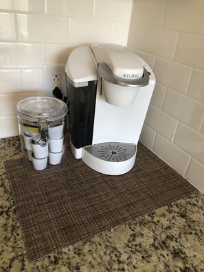 A Keurig coffee maker with a water reservoir and a coffee pod holder on a kitchen counter.