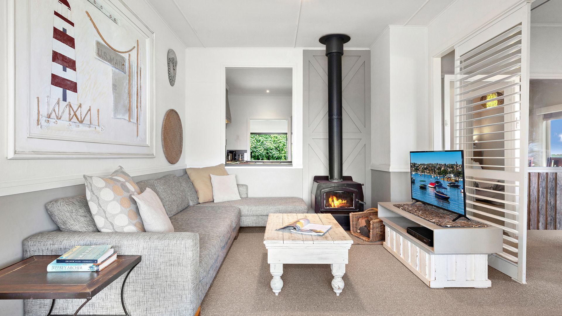 A living room with a sofa, a coffee table, a television, and a fireplace.
