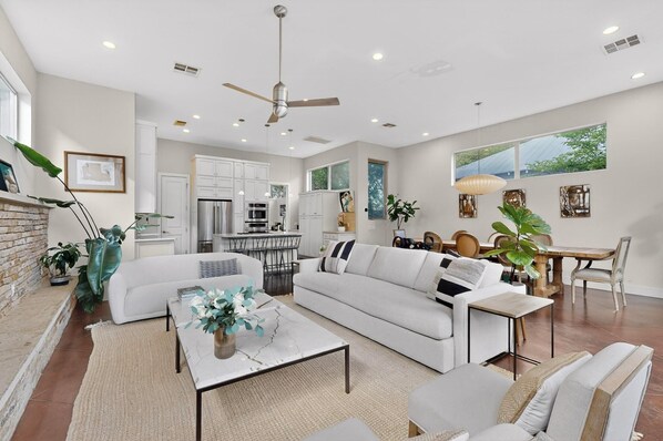 A modern living room with a sofa, coffee table, and dining area.