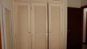 Una habitación con una puerta cerrada color beige y una puerta de madera.