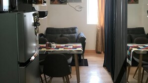 A compact living space with a kitchenette, a dining area, and a sofa. - Happy Place at Trees Residences Fairview (Quezon City)