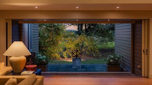 Un intérieur moderne donnant sur un jardin, avec une porte ouverte.