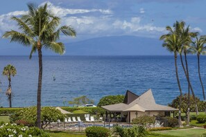 Un resort con piscina, sillas de descanso y vistas al océano.