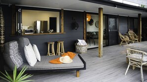 A modern outdoor seating area with a sofa, chairs, and a dining table. - The Werri Shack, Gerringong (Gerringong)