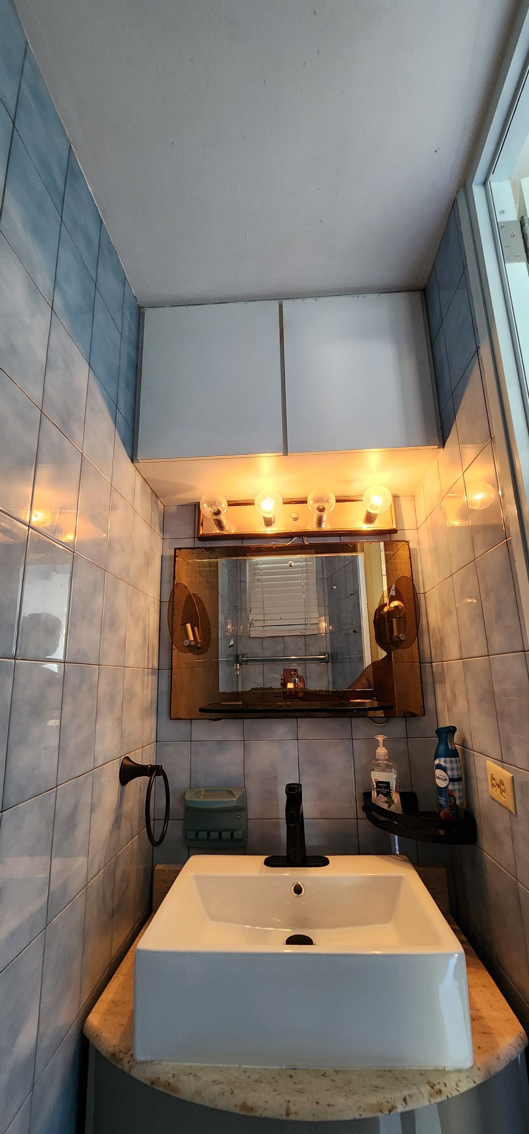 A bathroom with a white sink, a mirror, and a towel rack.
