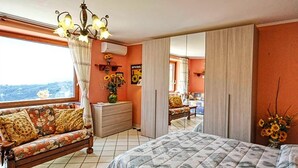 Un dormitorio con cama, sofá, cómoda y espejo.