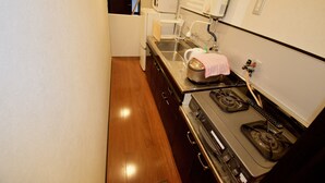 Cocina compacta con estufa, lavaplatos y microondas.