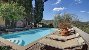 Ein Swimmingpool mit Liegestühlen und einer Topfpflanze.