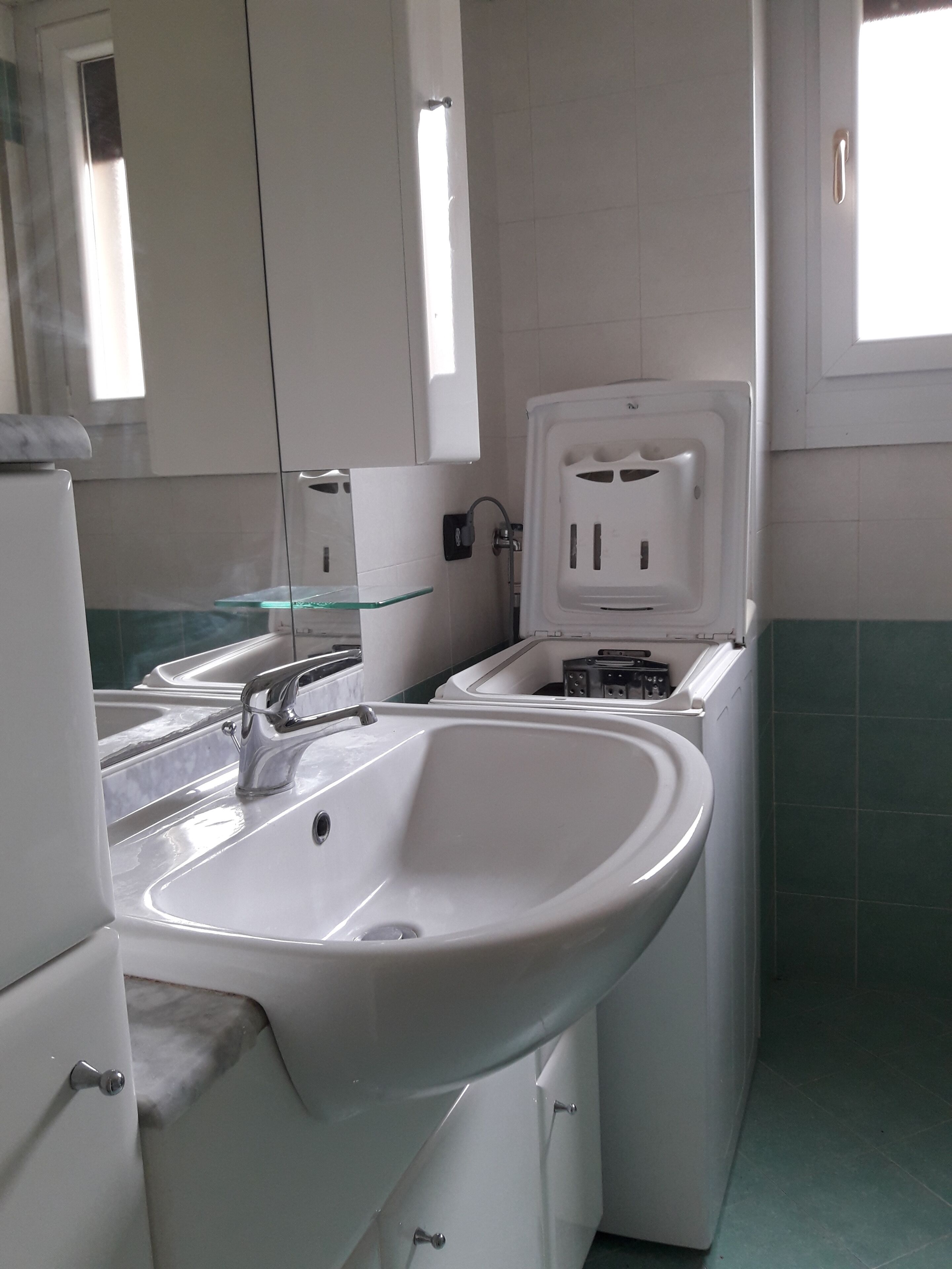 Une salle de bain avec un lavabo, un miroir et des toilettes.