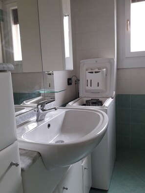 Une salle de bain avec un lavabo, un miroir et des toilettes.